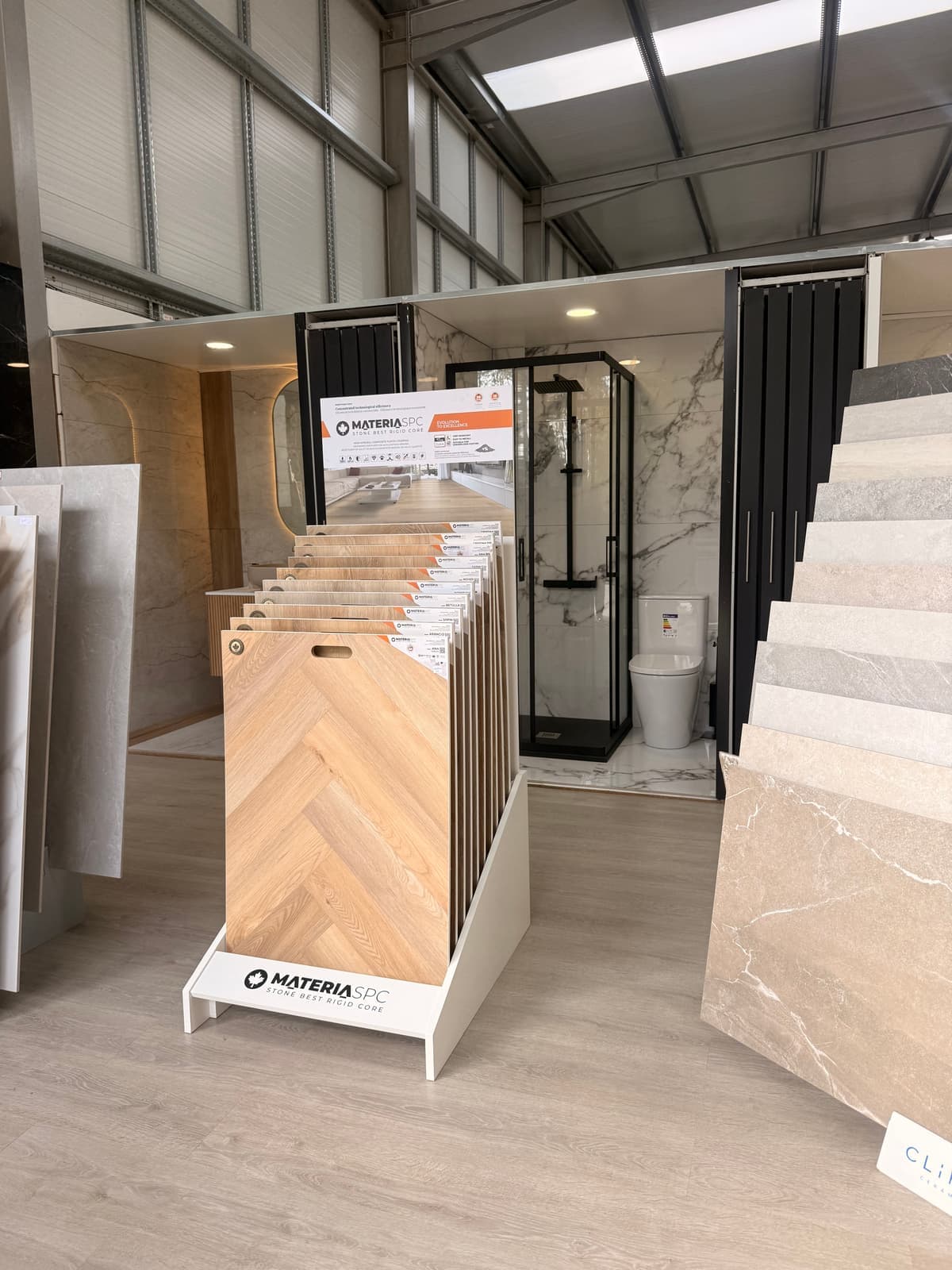Expositor de pavimentos vinílicos SPC com ambiente de duche em fundo no showroom