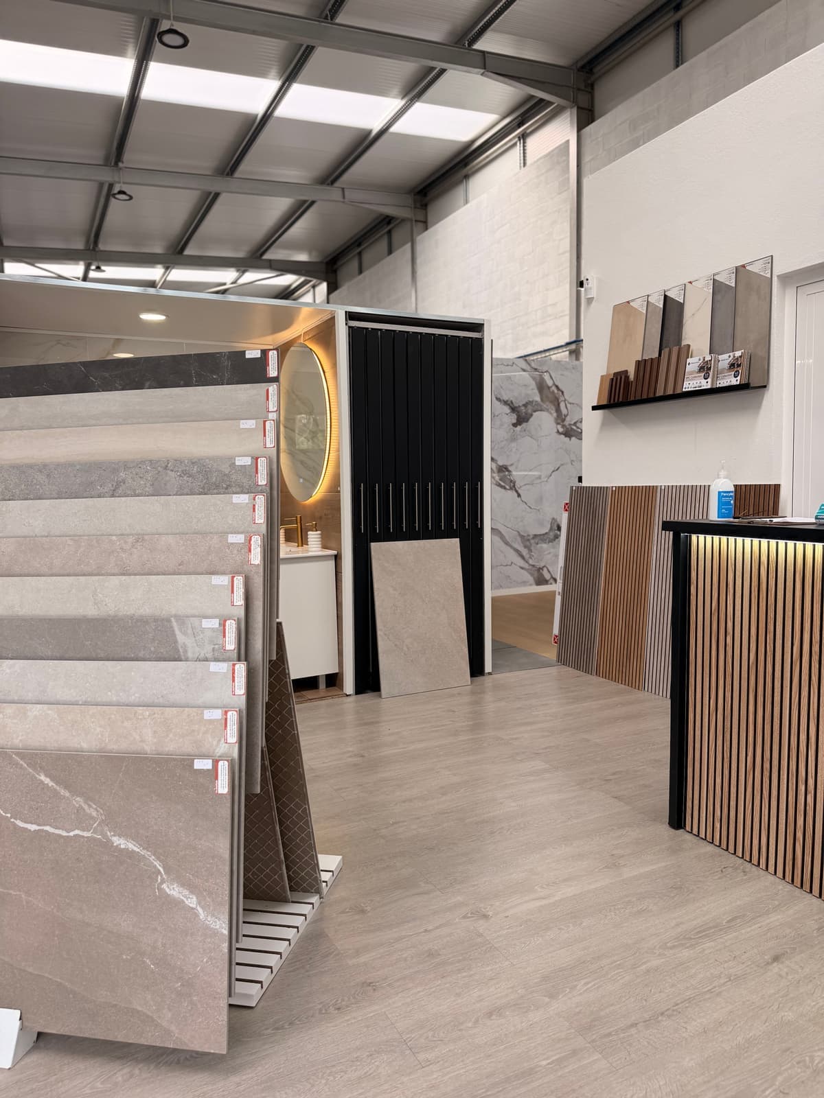 Balcão de atendimento do showroom com expositores de cerâmica e painéis ripados
